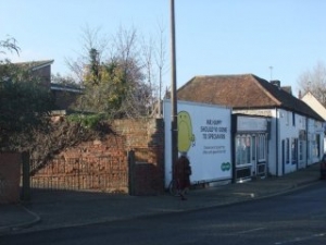 A town site with proposed planning for 4 flats to replace shop and billboard.
